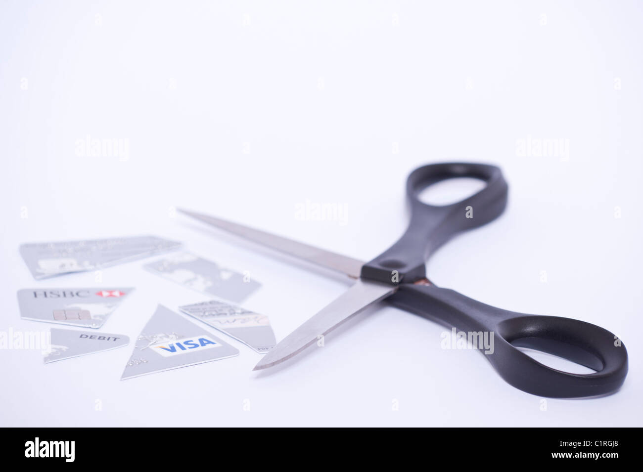 Una carta di debito che è stato tagliato con un paio di forbici su sfondo bianco Foto Stock