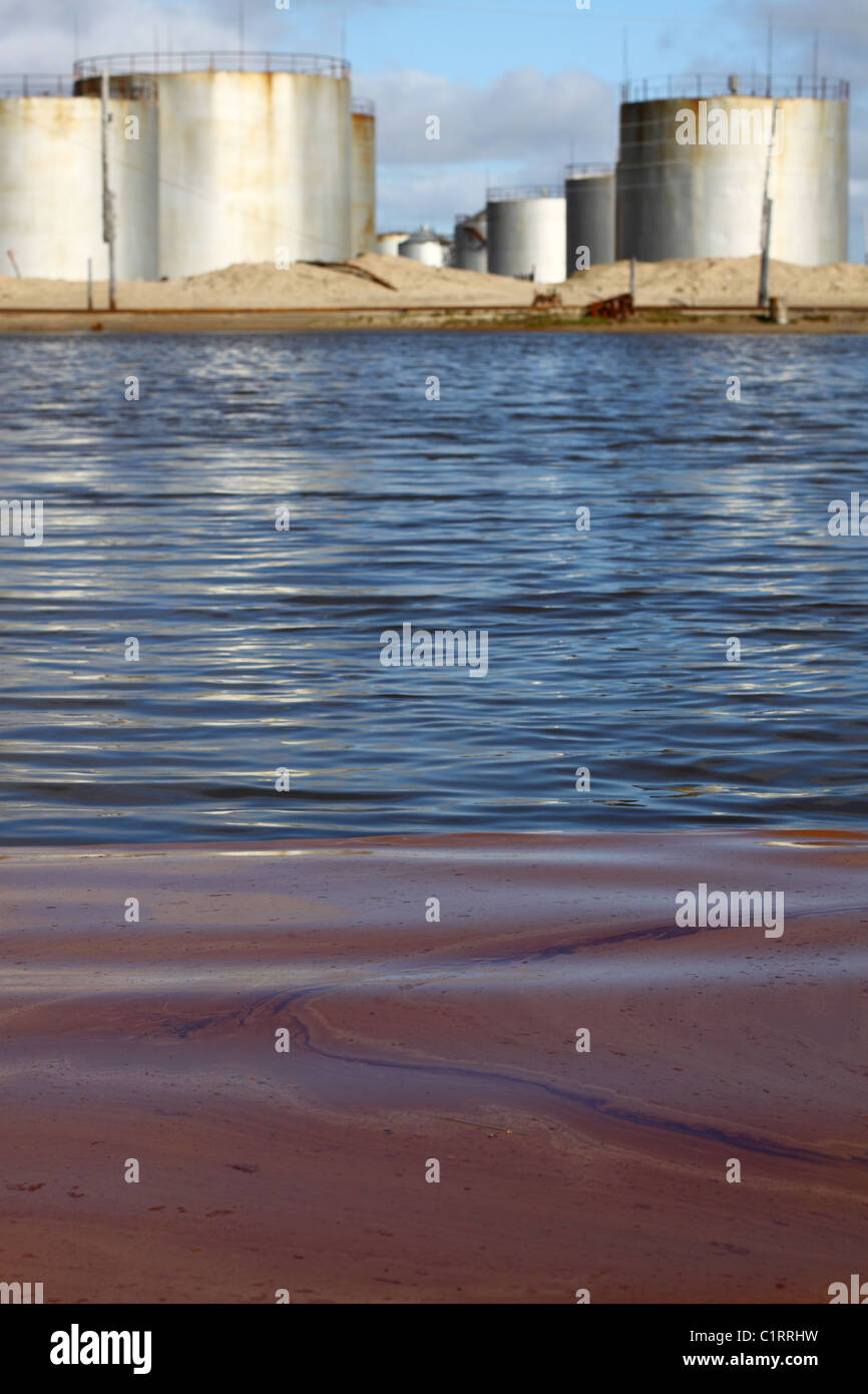 La superficie dell'acqua è inquinato dal carburante. Su uno sfondo con capacità di carburante sono visibili. Foto Stock
