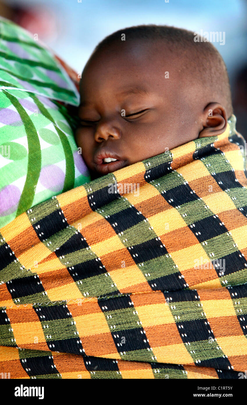 Bambino trasportato su madre torna, Senegal Africa Foto Stock