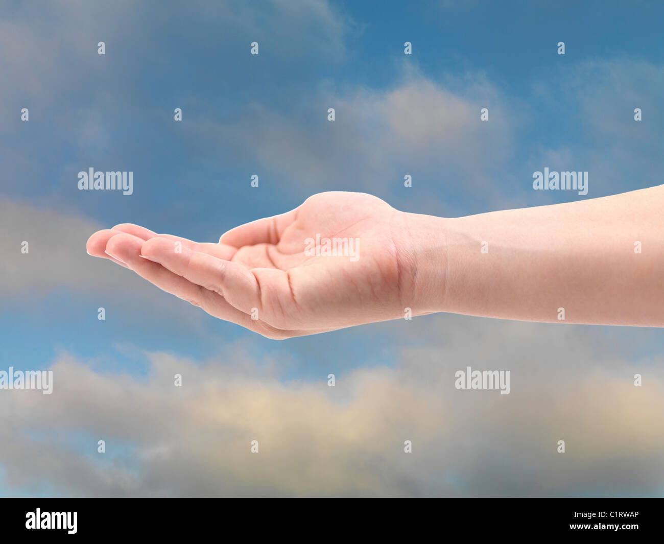 Una mano femmina isolati contro un cielo blu Foto Stock