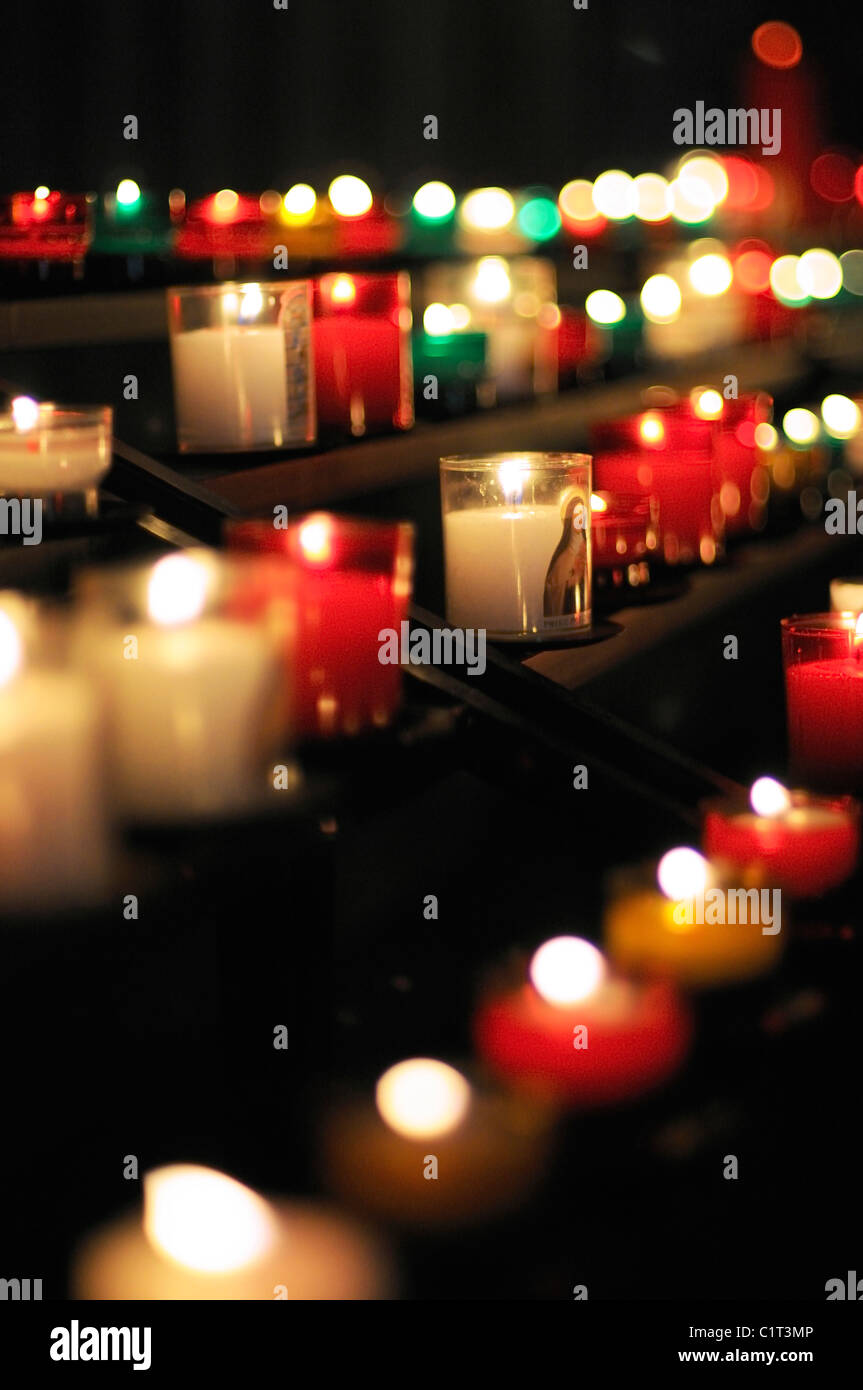 Candele votive bruciare nella chiesa Foto Stock