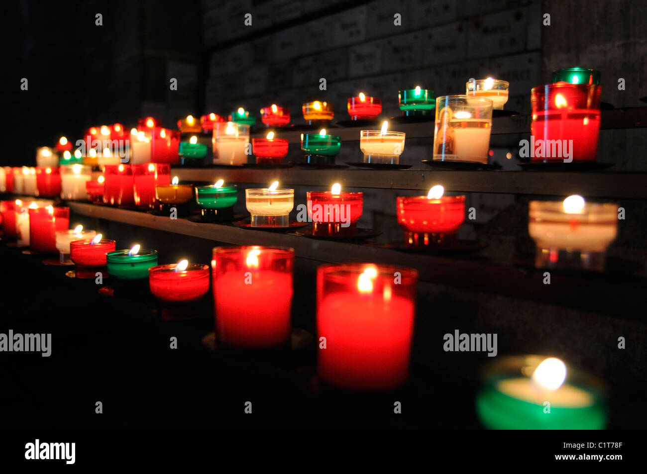 Candele votive bruciare nella chiesa Foto Stock