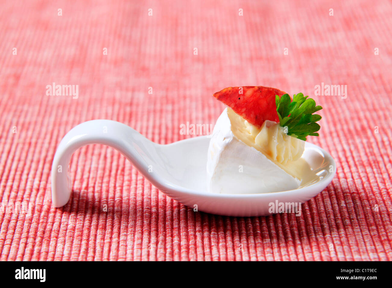 Formaggio antipasti su un cucchiaio di porcellana Foto Stock
