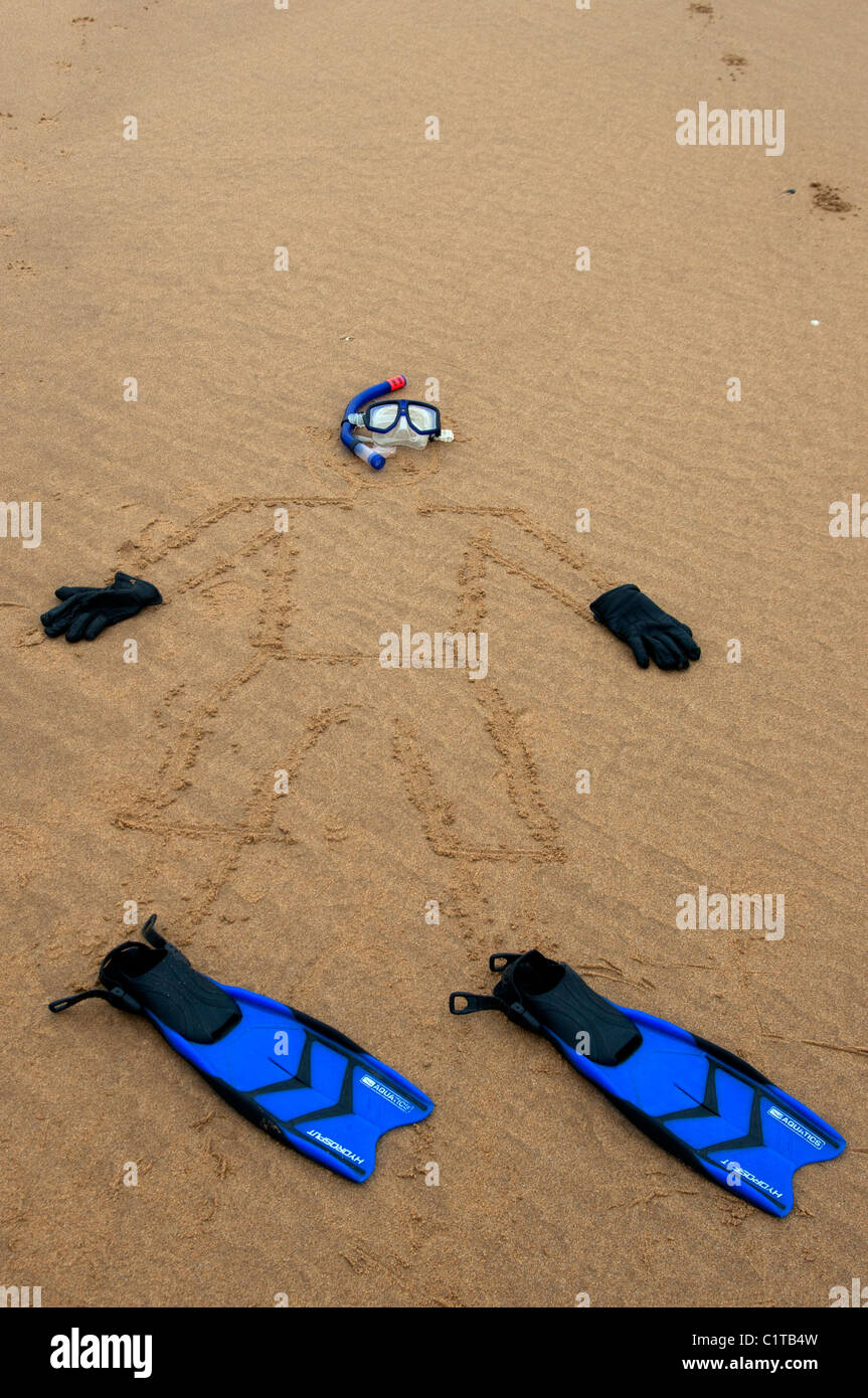 L'uomo trascinato in sabbia con pinne maschera e snorkel beach art Foto Stock
