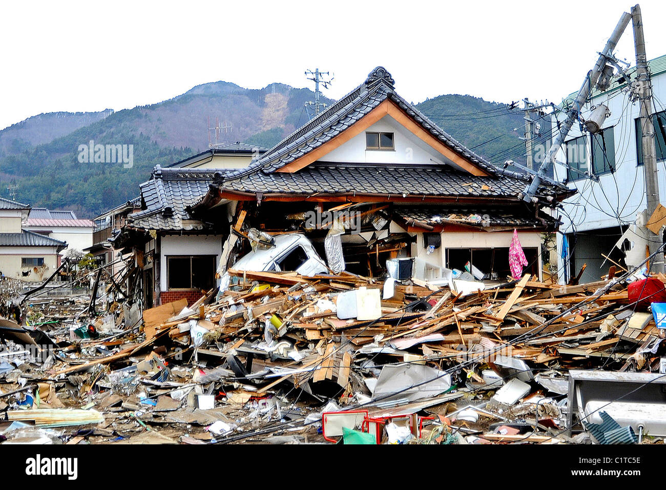 Casa si trova in macerie a seguito di un 8.9-terremoto di magnitudine, che ha innescato un devastante tsunami attraverso questa costiera giapponese Foto Stock