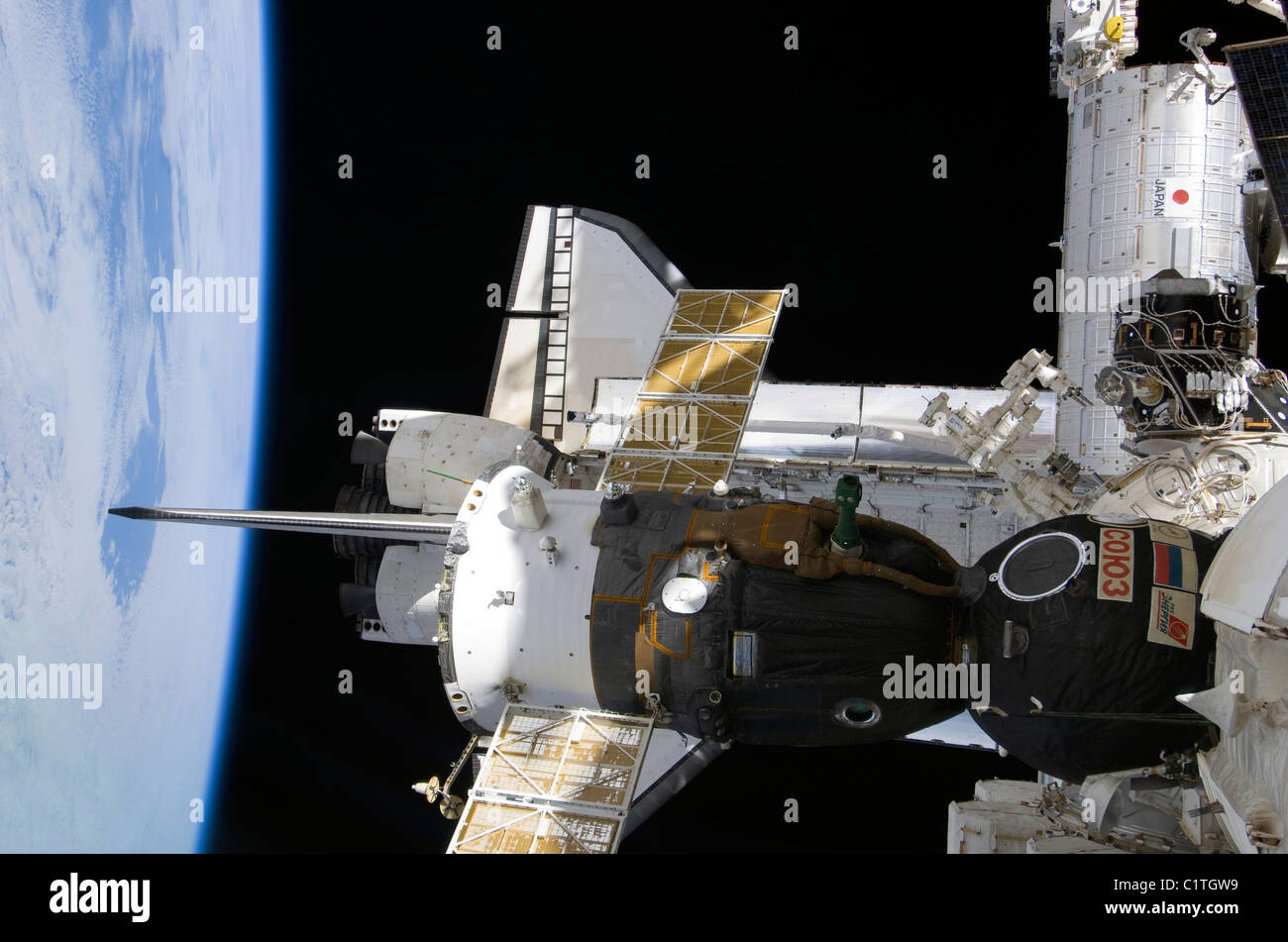 Un ancorate veicolo spaziale Soyuz oltre l'agganciato lo space shuttle Atlantis. Foto Stock