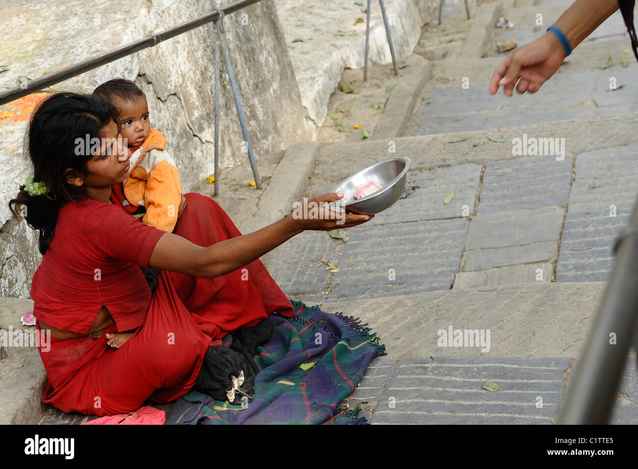 Madre tenendo il suo bambino mentre per l'accattonaggio denaro, i nepalesi , la vita a Kathmandu , kathmandu vita di strada , il Nepal Foto Stock