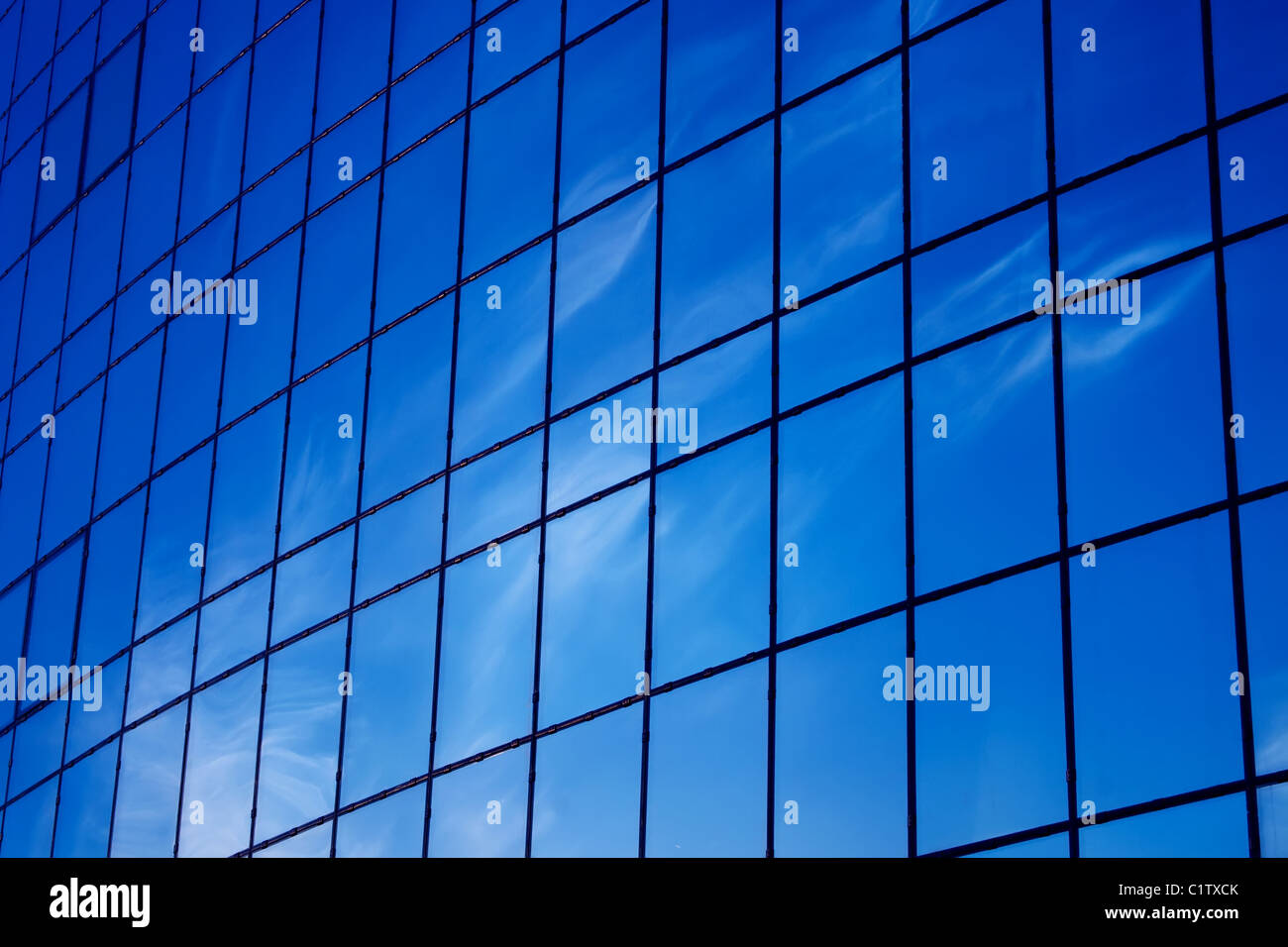 Moderni vetri da ufficio e riflessi blu del cielo nelle finestre Foto Stock