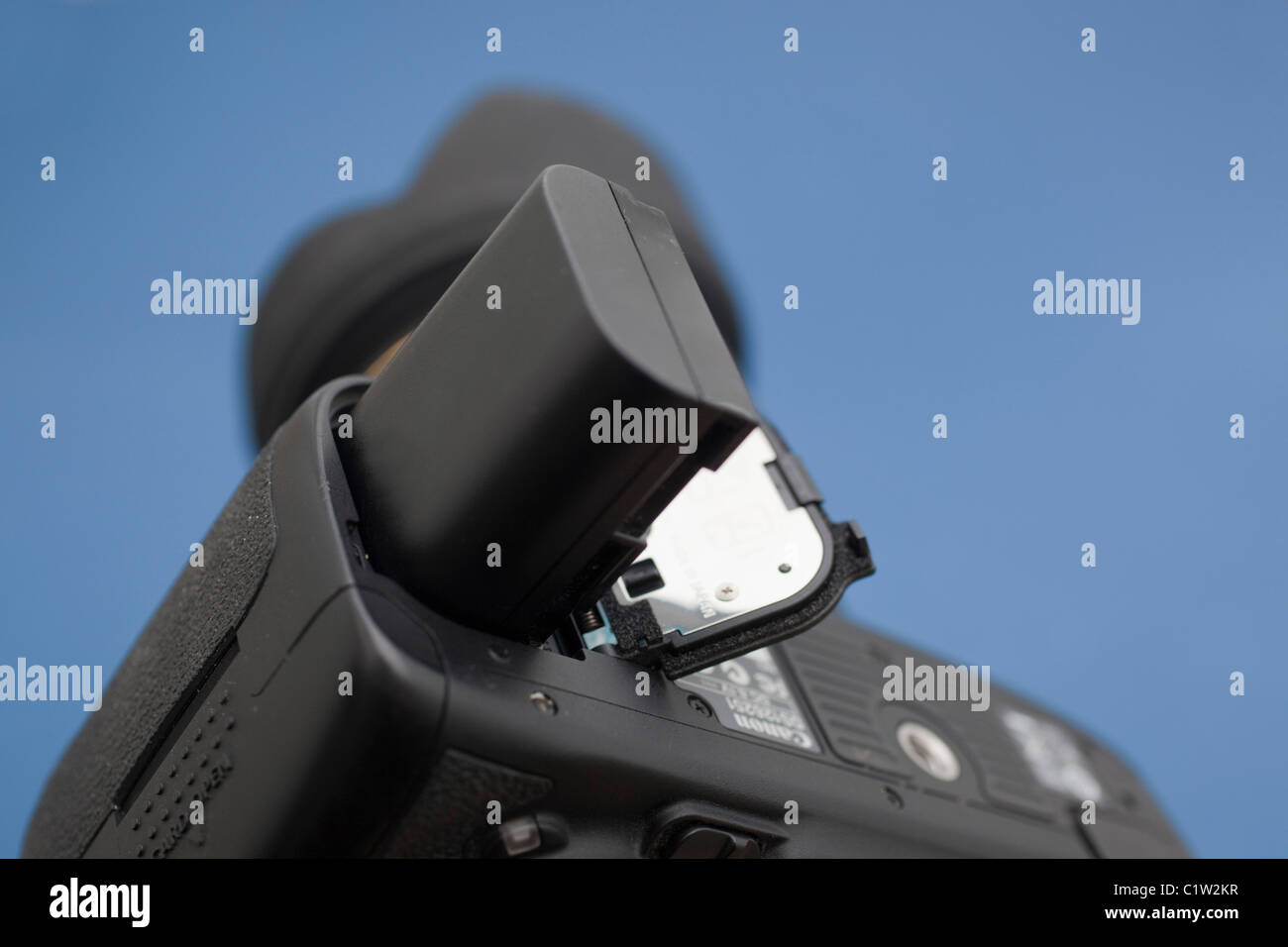 Inserimento di una batteria al litio in una fotocamera reflex digitale Foto Stock