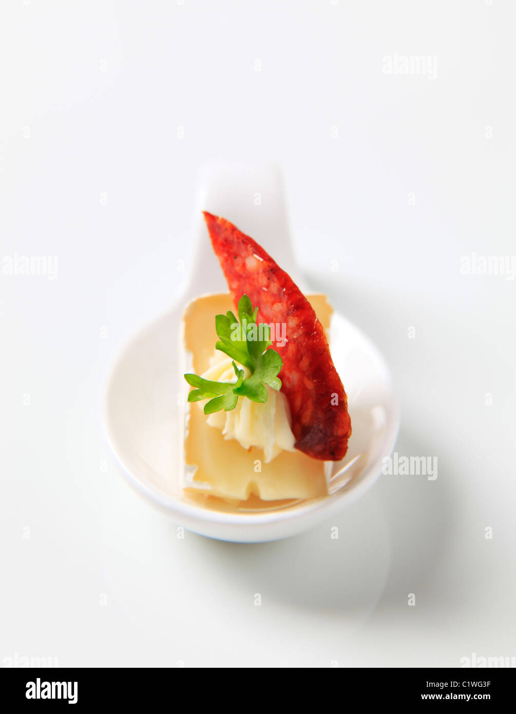 Formaggio antipasti su un cucchiaio di porcellana Foto Stock