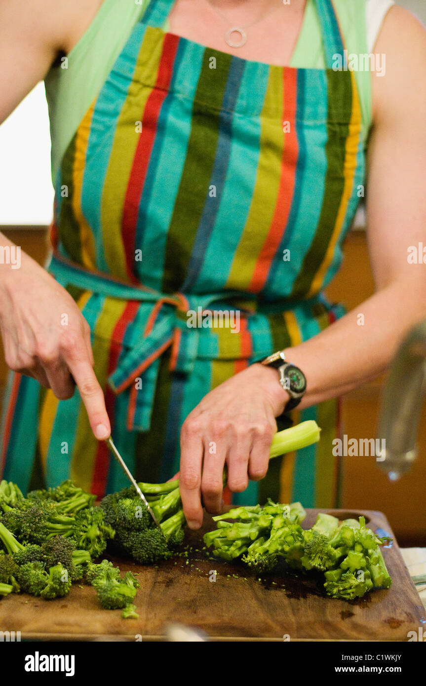 Metà vista in sezione di una donna il taglio di broccoli Foto Stock