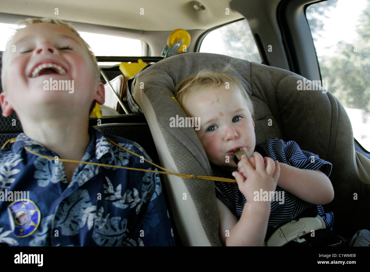 2 Fratelli giocando fuori nel retro del mini-van durante una vacanza in famiglia. Foto Stock