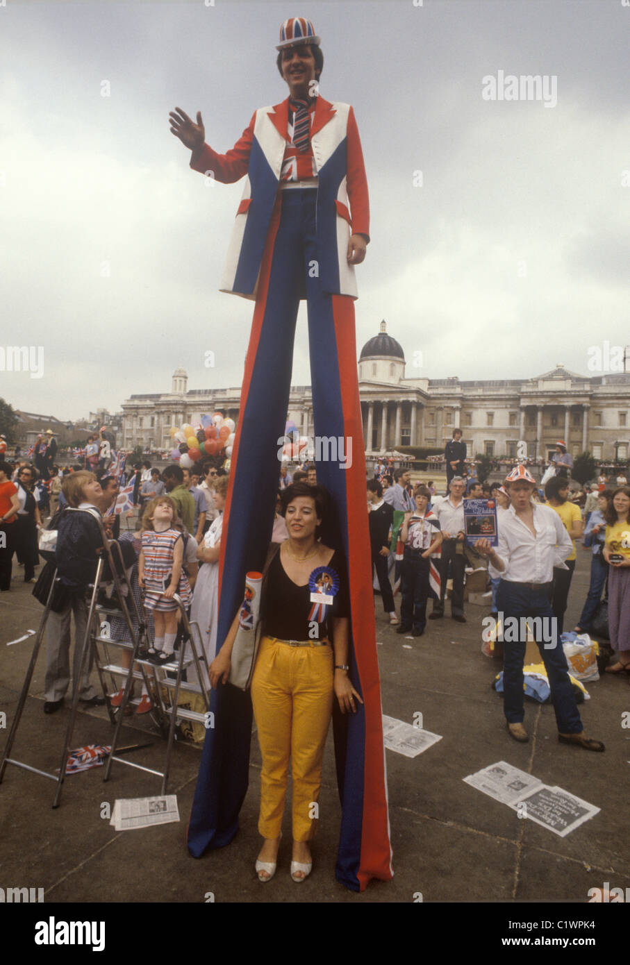 Matrimonio reale del principe Carlo e di Lady Diana Spencer Trafalgar Square uomo patriottico che utilizza palafitte per vedere la folla. Bambini sulle scale che cercano di vedere anche la processione. Luglio 1981 1980 nel Regno Unito HOMER SYKES Foto Stock