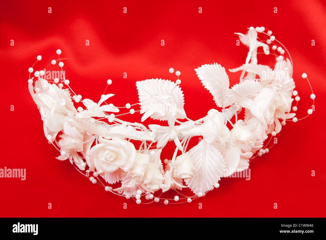 Sposa la ghirlanda di fiori bianchi su uno sfondo rosso Foto Stock