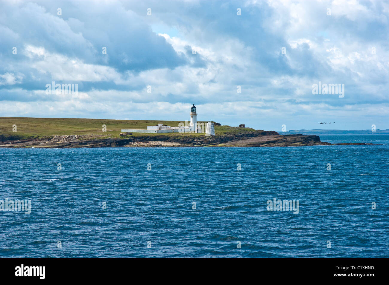 Faro sull isola di stroma che giace tra le Orcadi e il nord della Scozia nel Pentland Firth Foto Stock