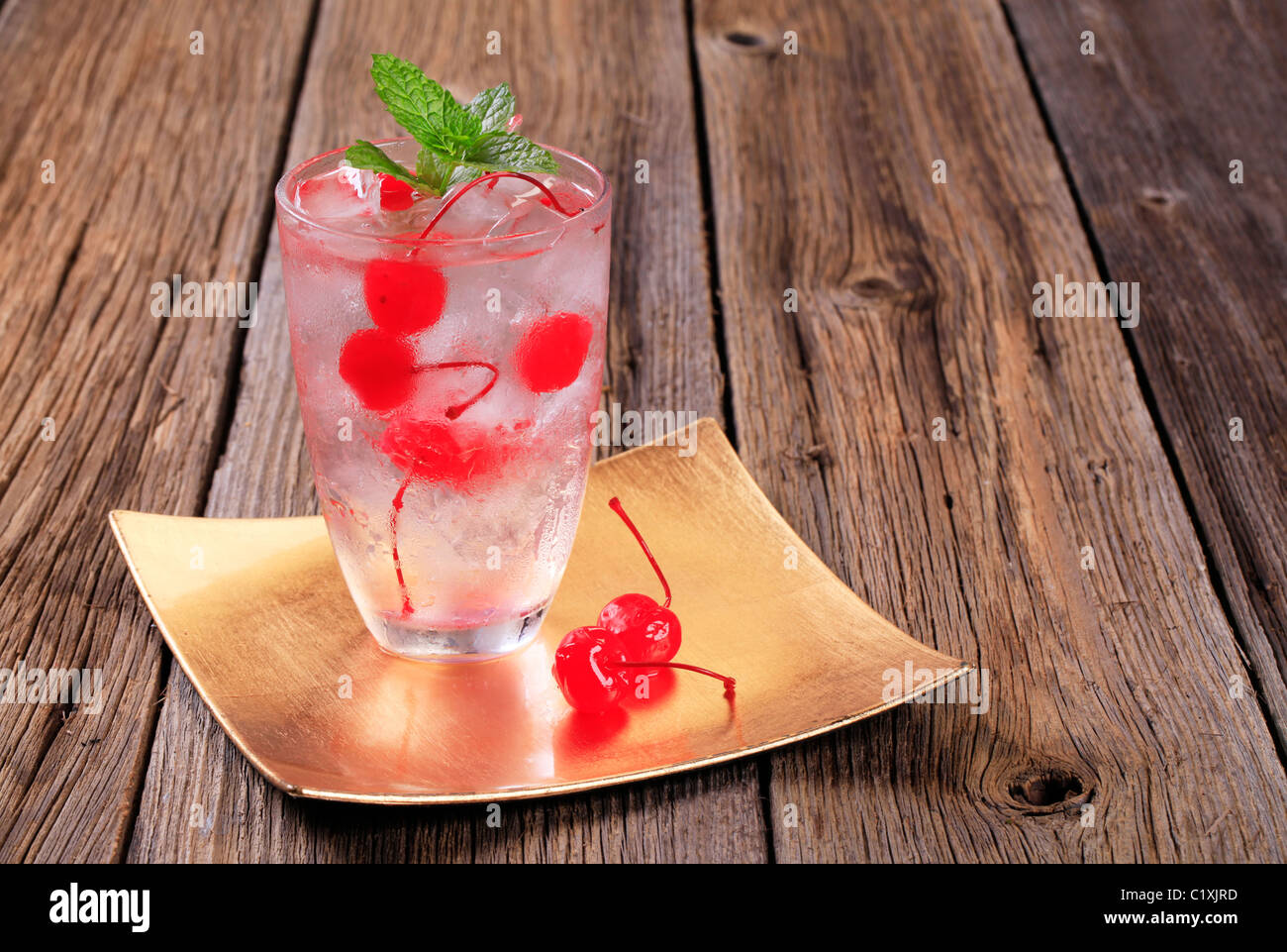 Bicchiere di bevanda ghiacciata con ciliegie al maraschino Foto Stock