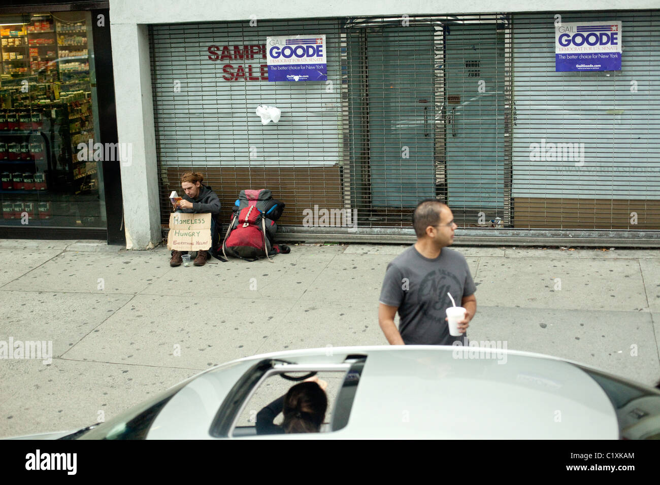 Senzatetto uomo seduto su un marciapiede in New York City USA Foto Stock