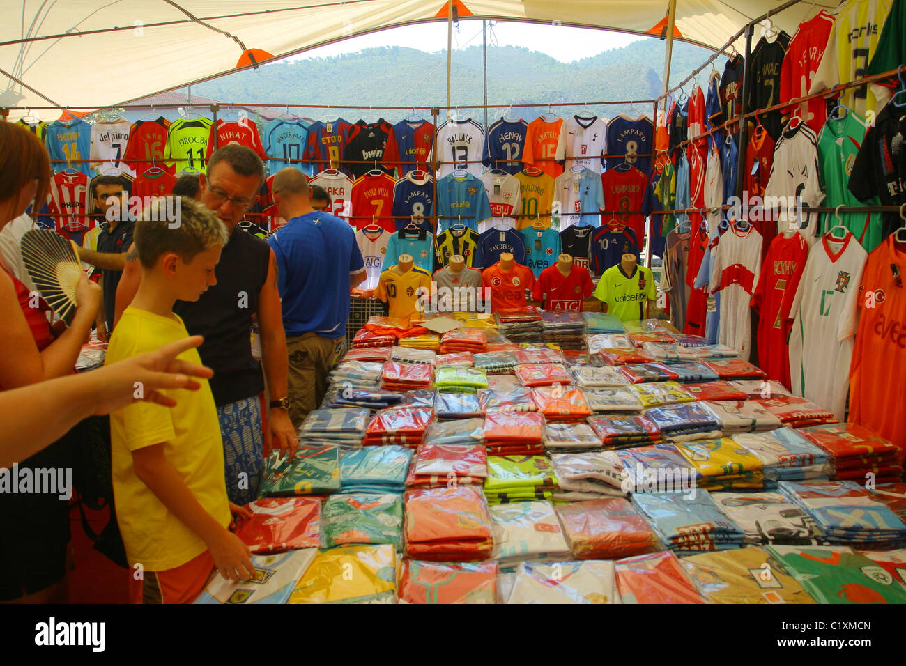 Ragazzo sceglie un fake replica kit calcio nel mercato locale in Fethiye. Mugla, Turchia Foto Stock