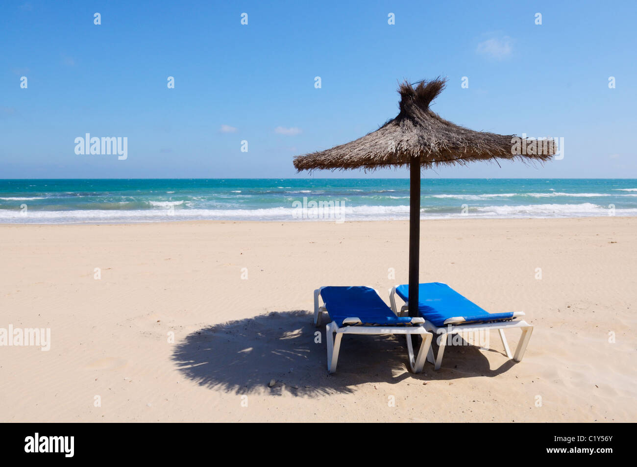 Lettini e ombrellone su un Mediterraneo spagnolo spiaggia. Dehesa de  Campoamor, Orihuela, provincia di Alicante, Spagna Foto stock - Alamy