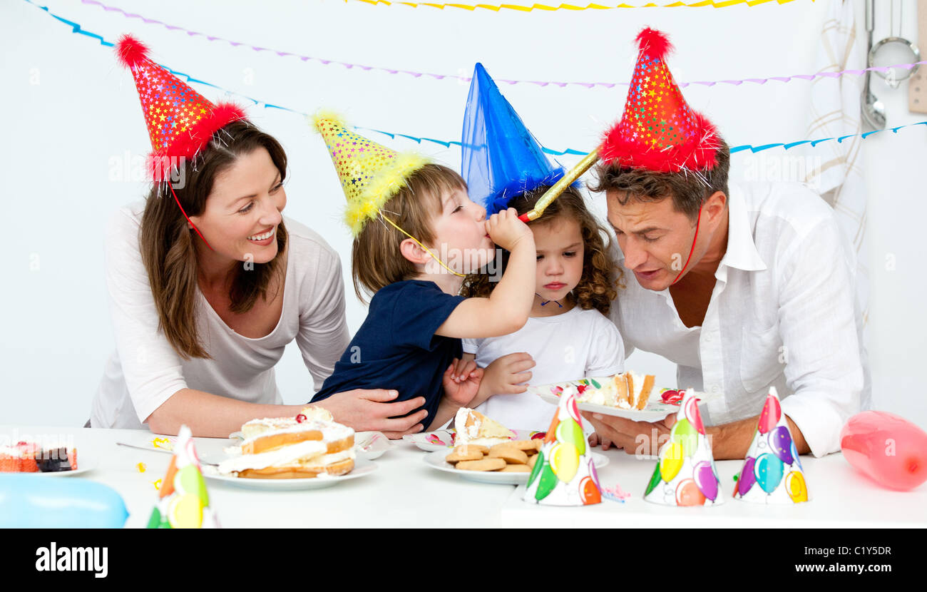 La famiglia felice avente fn mentre mangia torta di compleanno Foto Stock