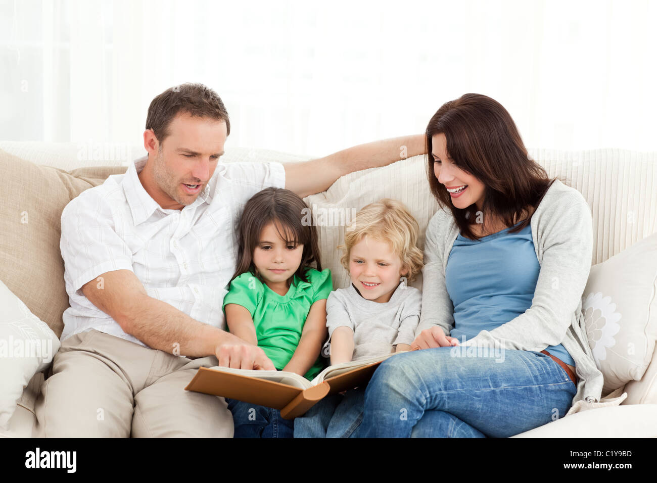 La famiglia felice guardando una foto album insieme Foto Stock