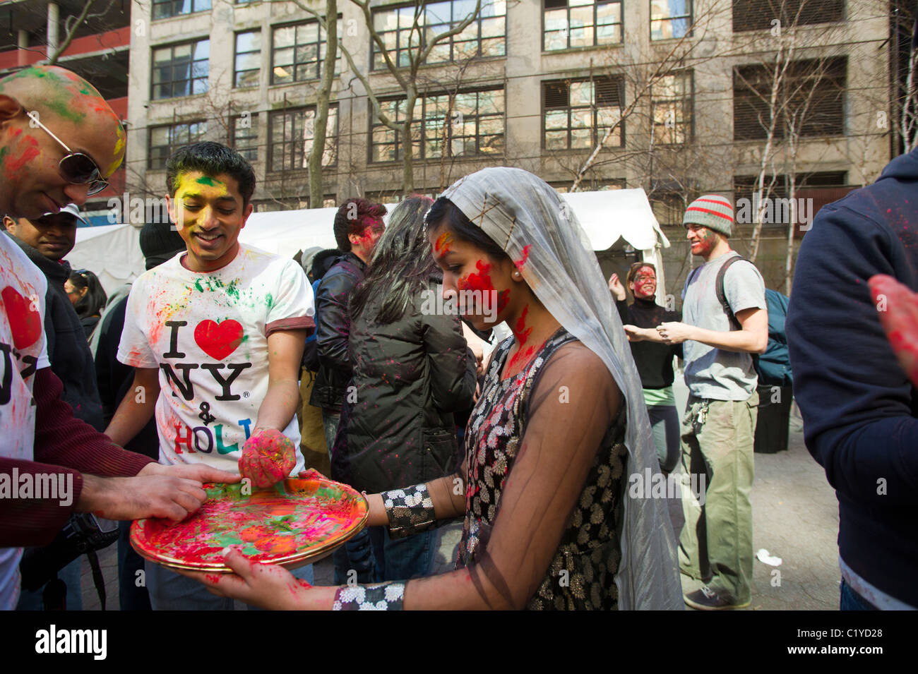 Polvere colorata viene applicata per i volti dei partecipanti come si celebra la vacanza indiano di Holi a street festival di NY Foto Stock