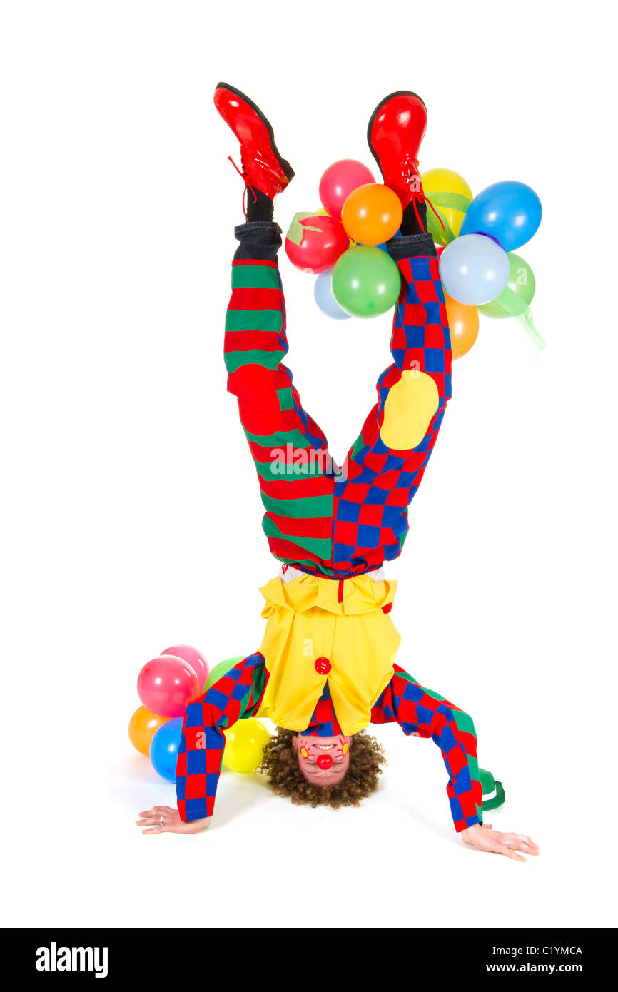 Funny clown con palloncini in headstand su sfondo bianco Foto Stock