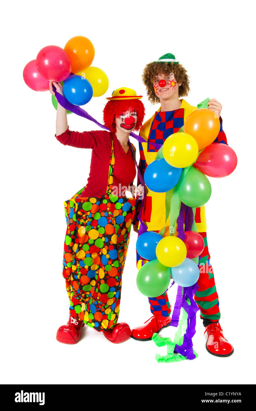 Giovane divertente pieno vestito clown con molti palloncini Foto Stock
