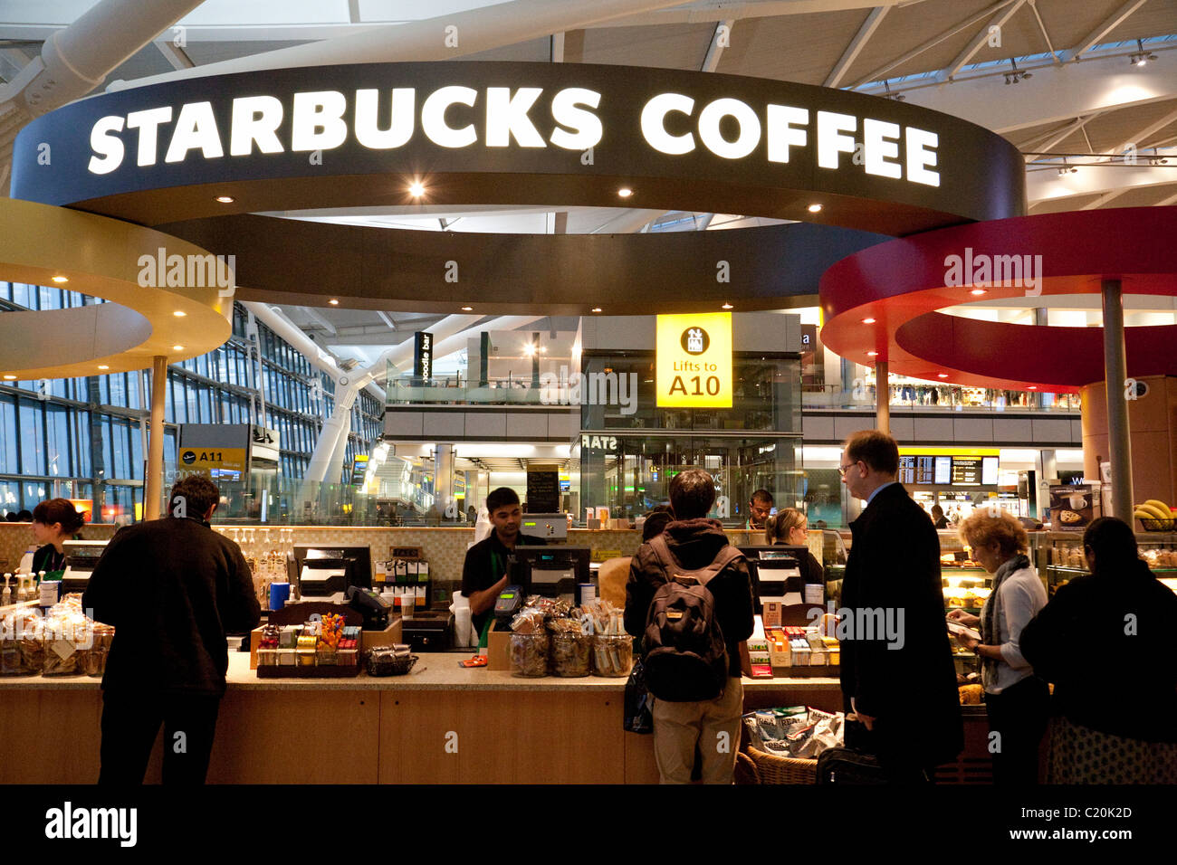 Persone che sono servite a Starbucks Coffee bar, nel terminal 5 di Heathrow, London REGNO UNITO Foto Stock