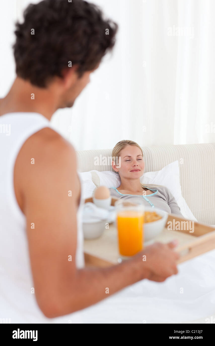 L'uomo portare la colazione a sua moglie Foto Stock