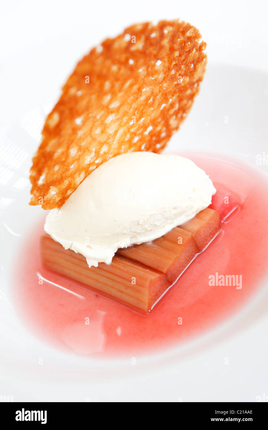 Dessert di rabarbaro speziato con panna e un brandy snap biscotto. Foto Stock
