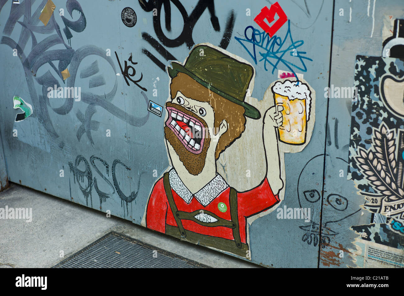 Poster di arte e di un cancello in acciaio che mostra una azienda bavarese un boccale di birra, Baaderstraße, Gärternplatzviertel, Monaco di Baviera Foto Stock