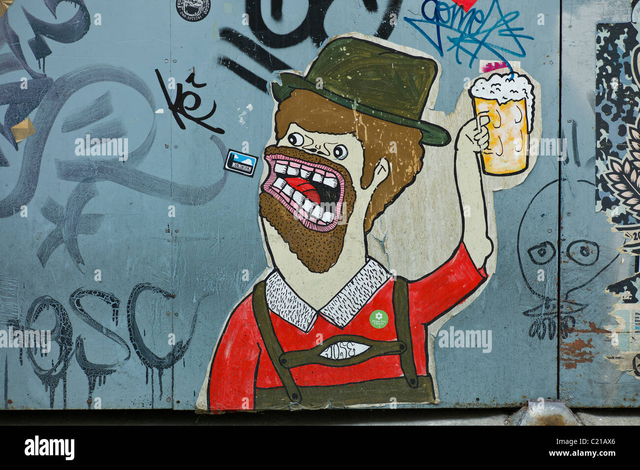 Poster di arte e di un cancello in acciaio che mostra una azienda bavarese un boccale di birra, Baaderstraße, Gärternplatzviertel, Monaco di Baviera Foto Stock
