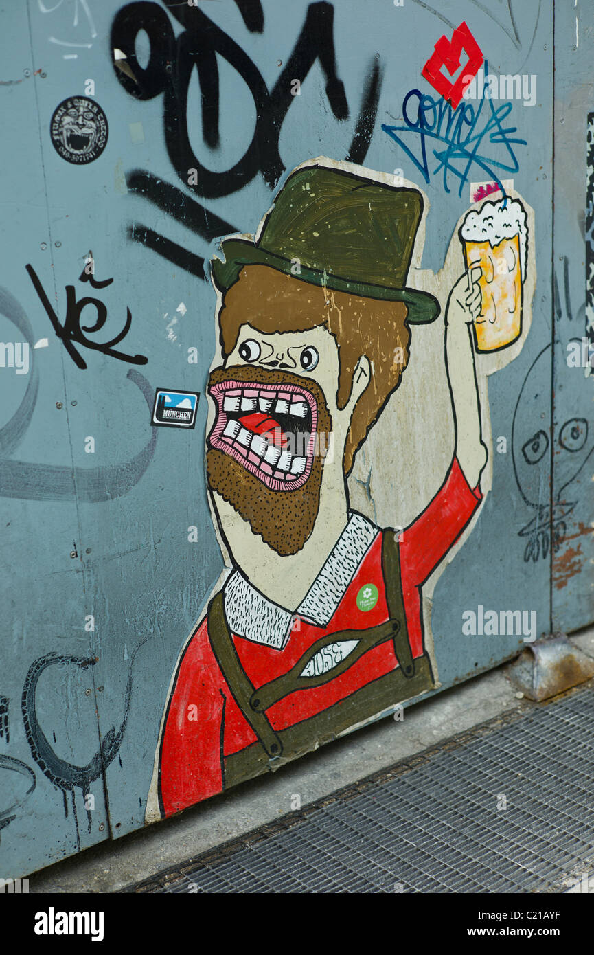 Poster di arte e di un cancello in acciaio che mostra una azienda bavarese un boccale di birra, Baaderstraße, Gärternplatzviertel, Monaco di Baviera Foto Stock