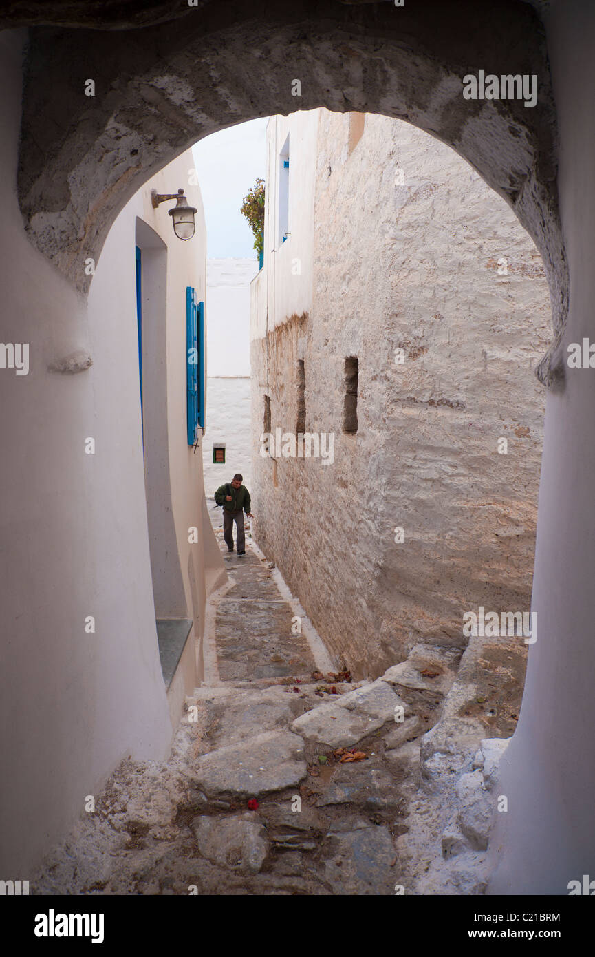 Uomo di arrampicarsi su un vicolo inclinata nel villaggio di Chora, sul Greco Cyclade isola di Amorgos. Foto Stock