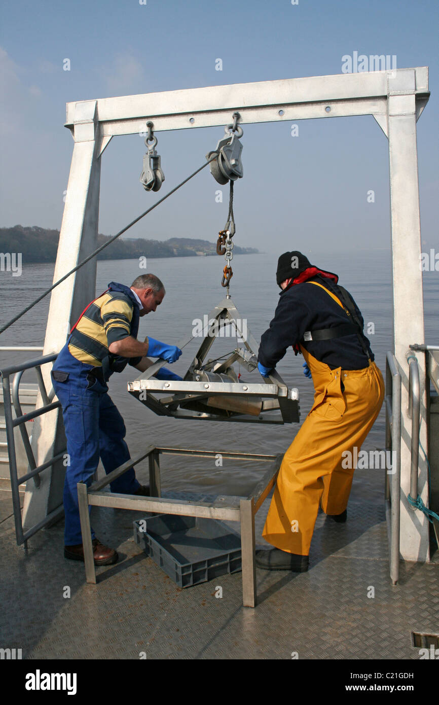 Scienziati marini raccolta sedimenti Grab campioni dal fiume Mersey, REGNO UNITO Foto Stock