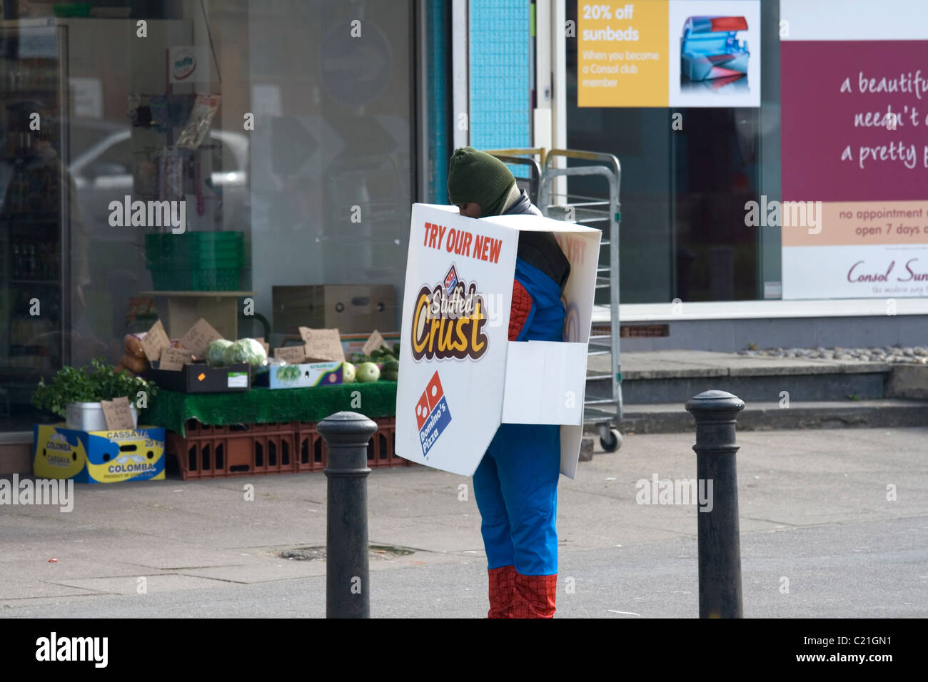Un sandwich board uomo vestito in un costume di Spiderman Foto Stock Un sandwich board uomo vestito in un costume di Spiderman Foto Stock