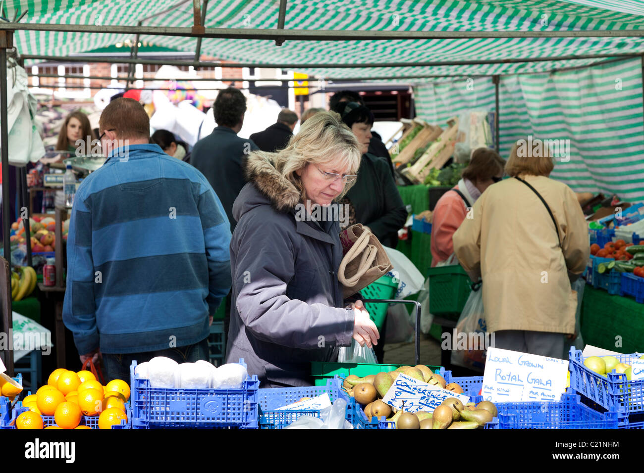 I clienti al mercato di frutta e verdura in stallo in town square Foto Stock