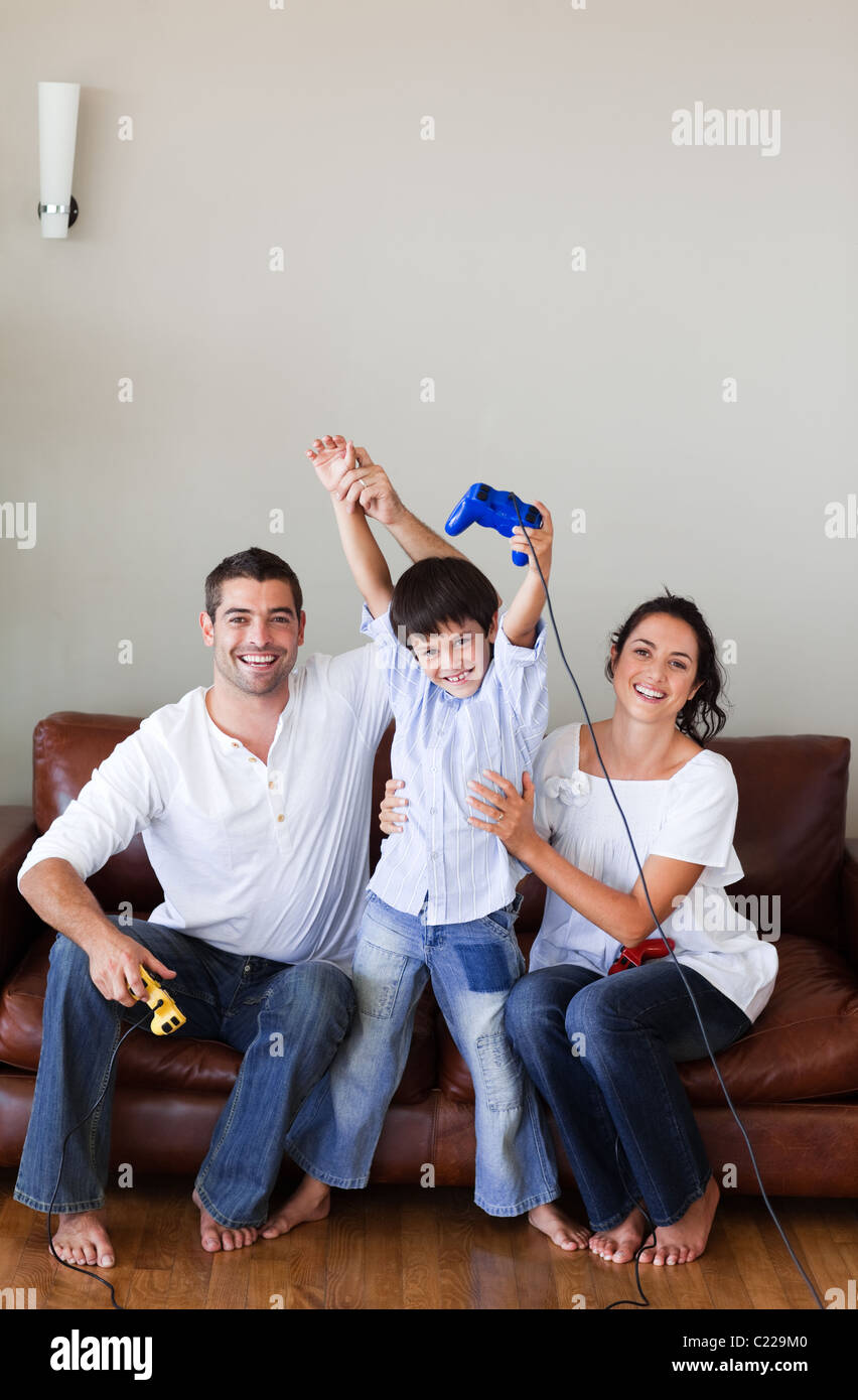 Ragazzo simpatico gioca con i suoi genitori video giochi Foto Stock