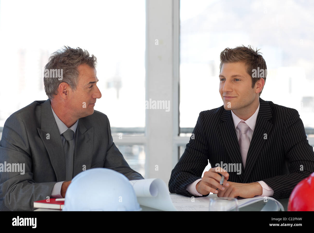 Due colleghi parlare insieme alla scrivania Foto Stock