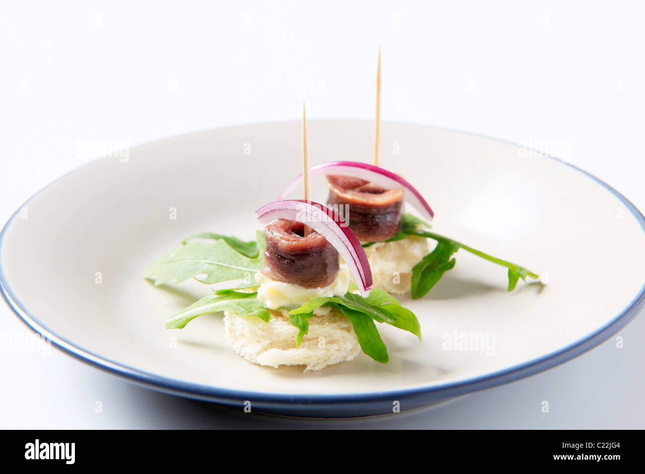 Crostini di acciuga guarnite con foglie di rucola Foto Stock