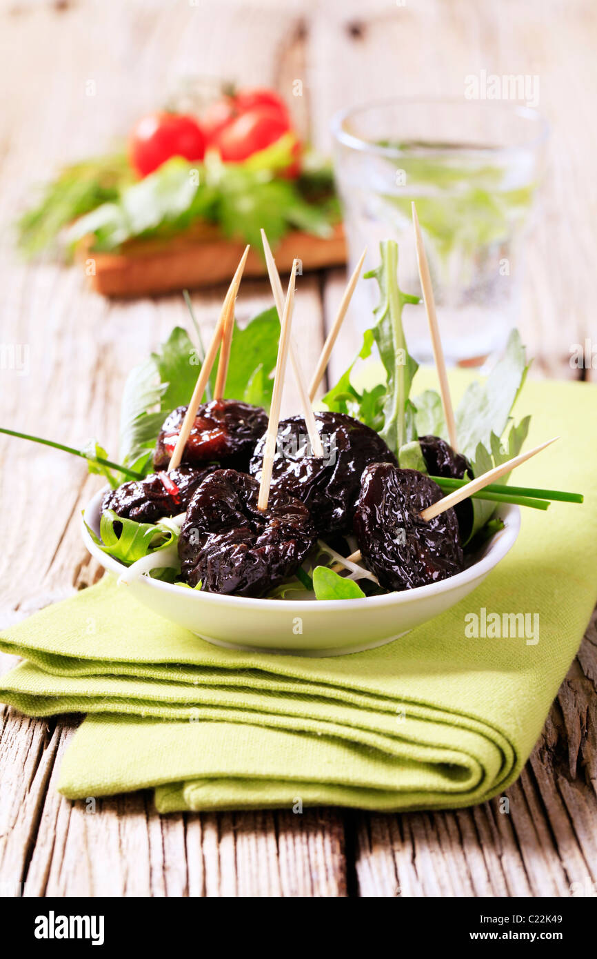 Ciotola di prugne il cocktail bastoncini - primo piano Foto Stock