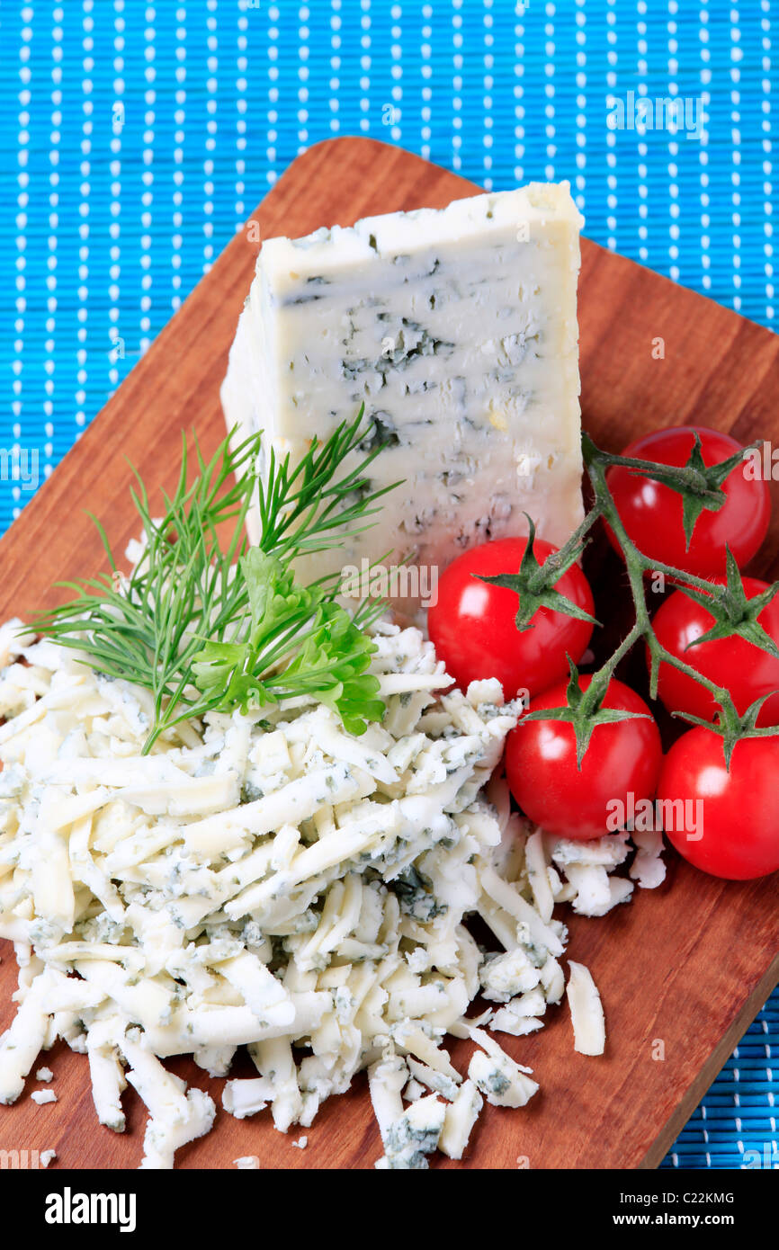 Formaggio blu e pomodori freschi su un tagliere Foto Stock