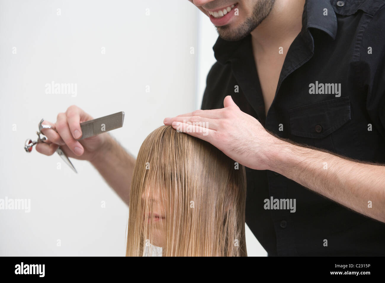 L'uomo il taglio e la pettinatura di una giovane donna capelli in parrucchieri Foto Stock