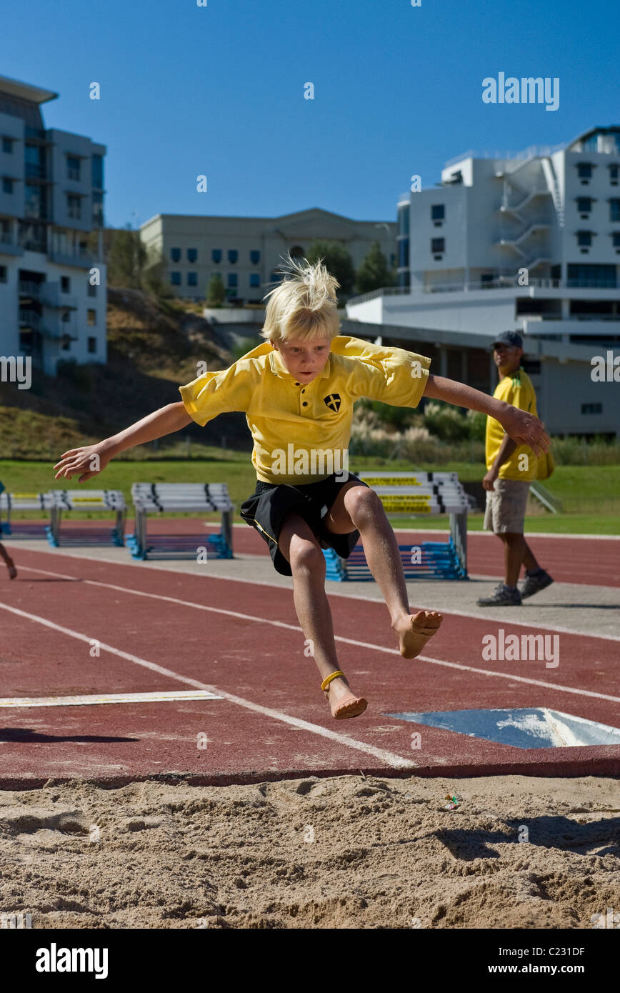 South African school boy in un salto in lungo la concorrenza, Bellvile, Western Cape, Sud Africa Foto Stock