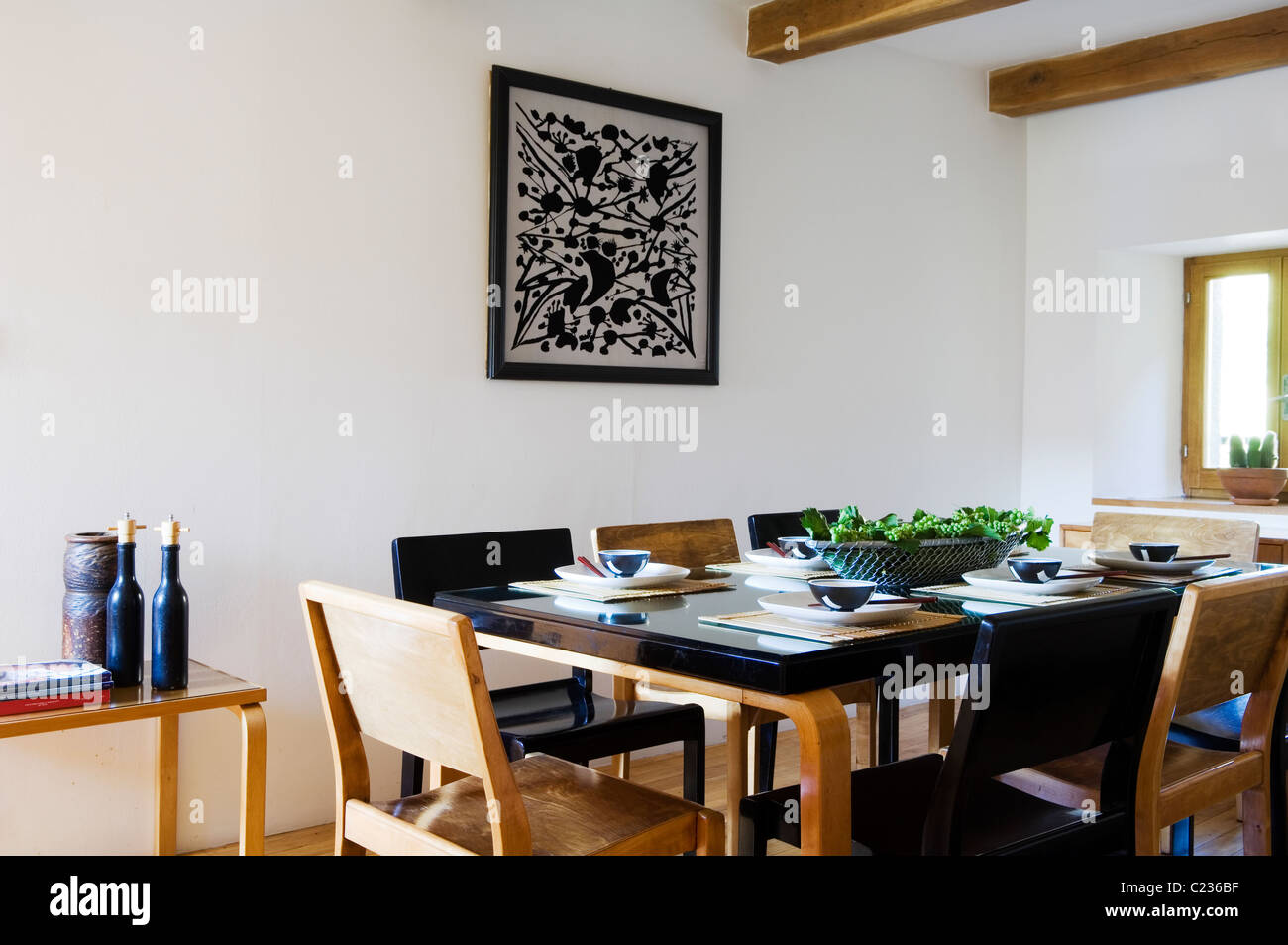 Un cui Alvar Aalto tavolo e sedie in bianco sala da pranzo con soffitto con travi a vista e Graham Sutherland silkscreen Foto Stock