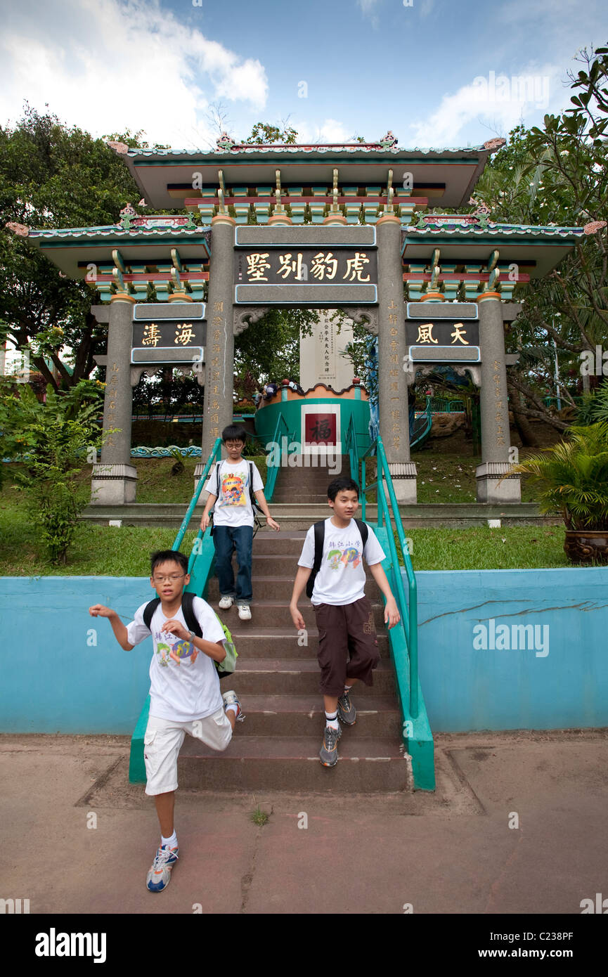 Tre ragazzi asiatici sui passaggi da esplorare le insolite Haw Par Villa parco a tema in Singapore Foto Stock