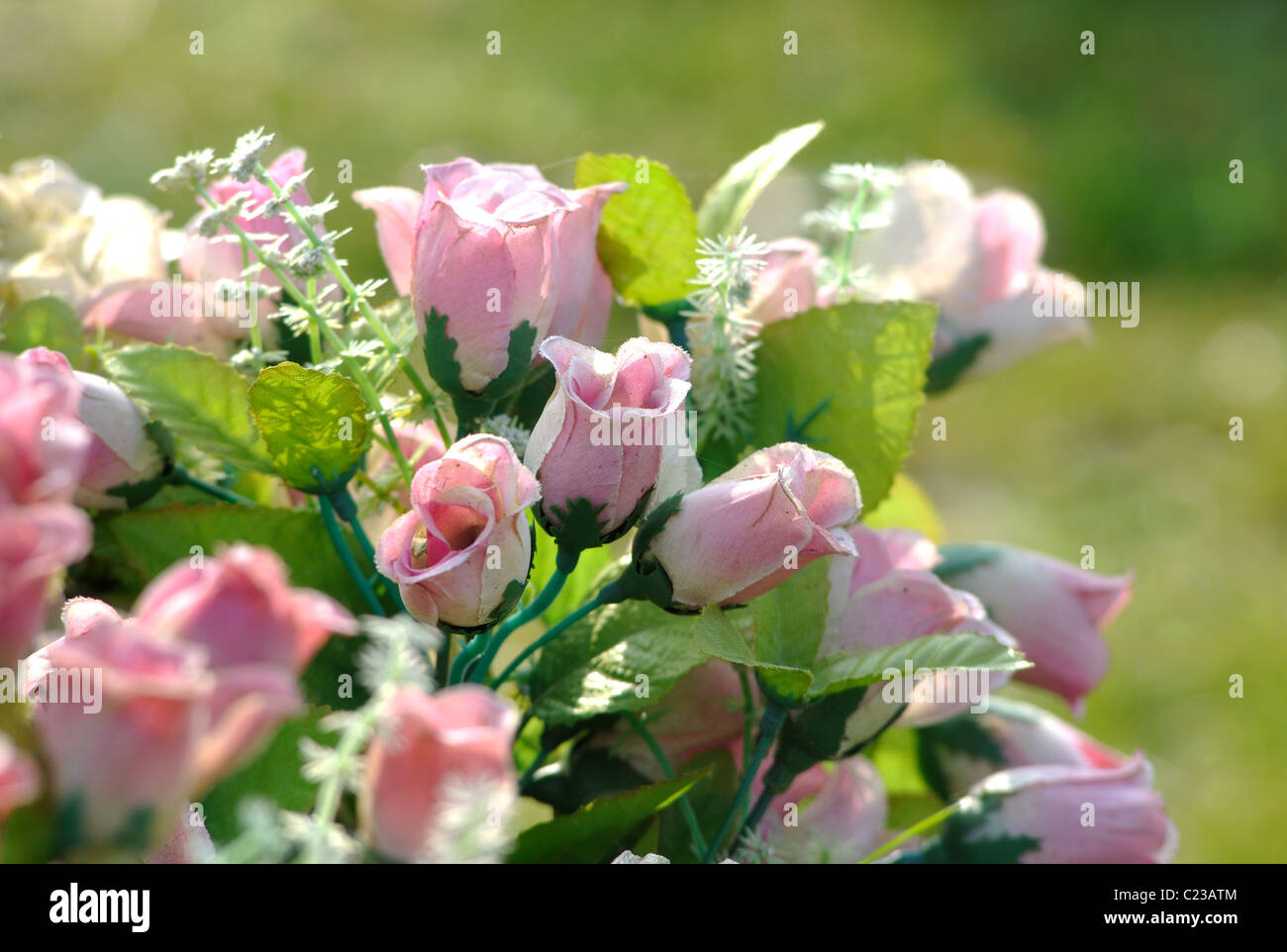 Fiori artificiali su una tomba Foto Stock