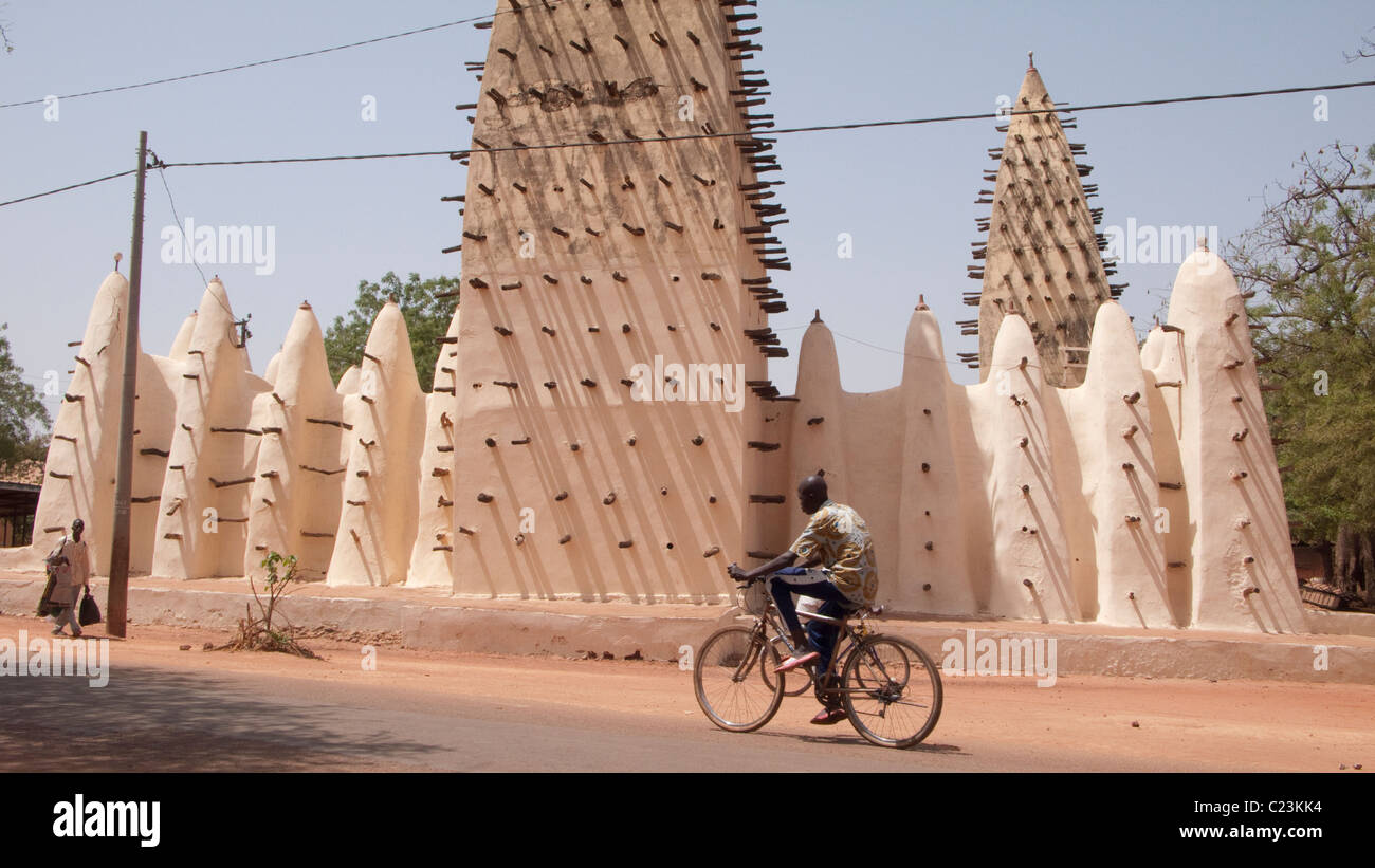 Un ciclista passa la Grande Mosquée di Bobo Dioulasso Foto Stock