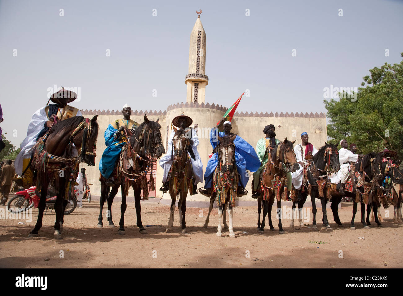 I partecipanti al FECHIBA horse festival line up davanti ad una moschea in Barani, Burlkina Faso, Africa occidentale Foto Stock